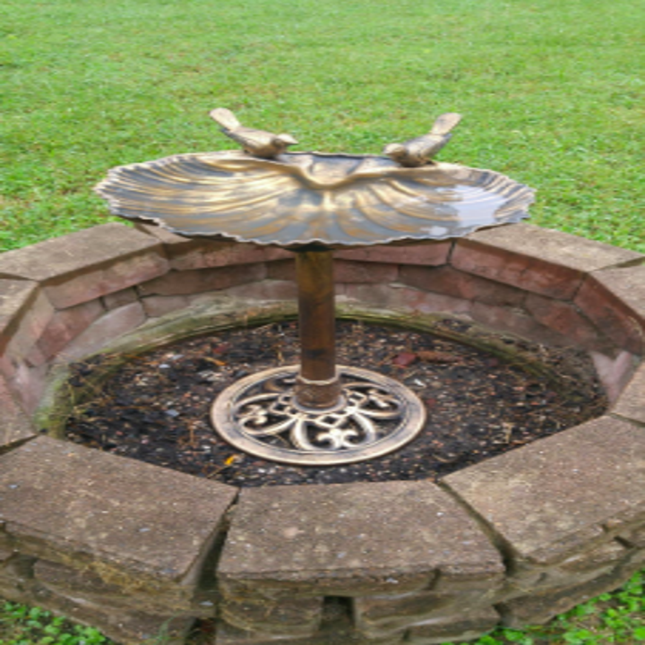 the bird bath with a small stone wall accent surrounding it
