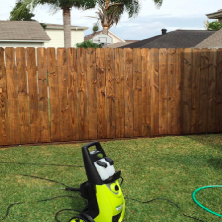 the same fence looking vibrant brown wafter using the pressure washer