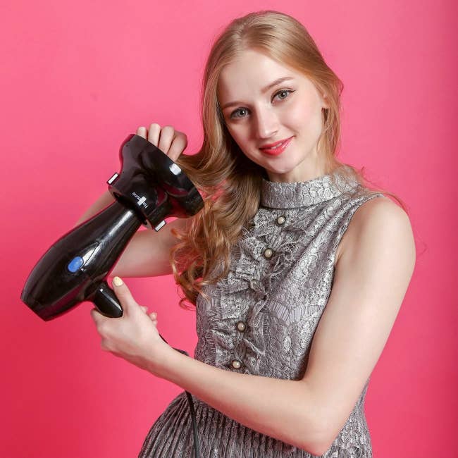 model uses hair dryer with device added to the end 