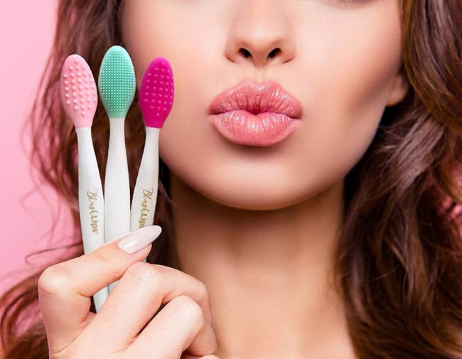 A model holding three scrubber lip brushes