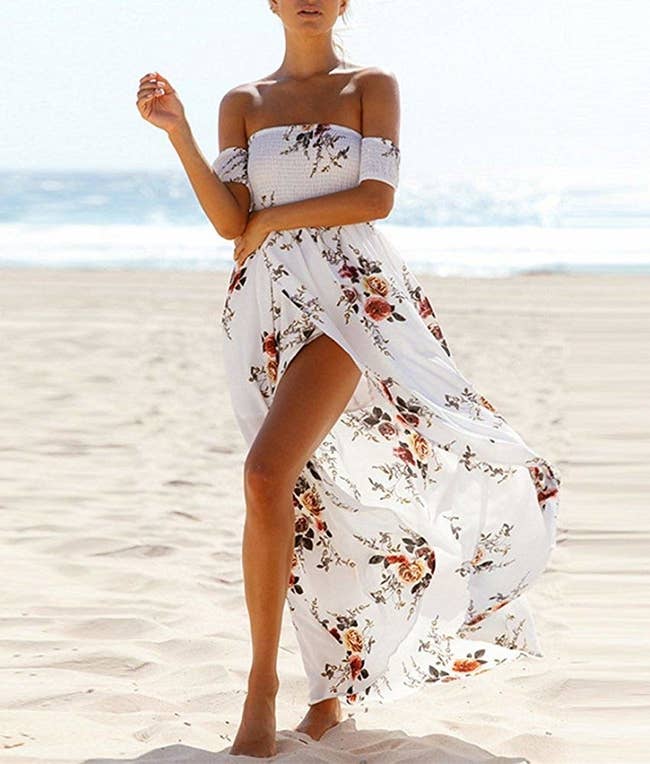 A model wearing the off-the-shoulder dress on a beach. 