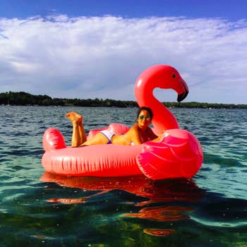 A reviewer lying on her stomach on the flamingo in body of water