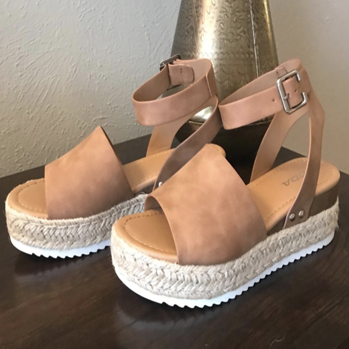 a reviewer's photo of the shoes with a ankle strap and buckle in tan
