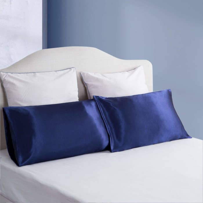 bed with navy satin pillowcases on a bed