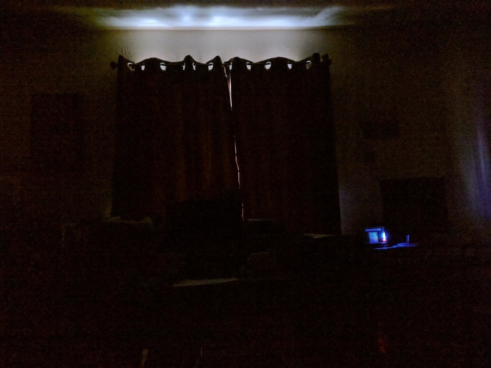 A review image of the curtains blocking out all the daylight, except a teeny strip at the top