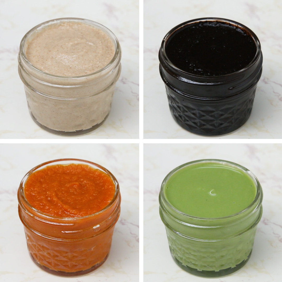 four clear containers containing green, orange, light brown, and dark brown liquid 