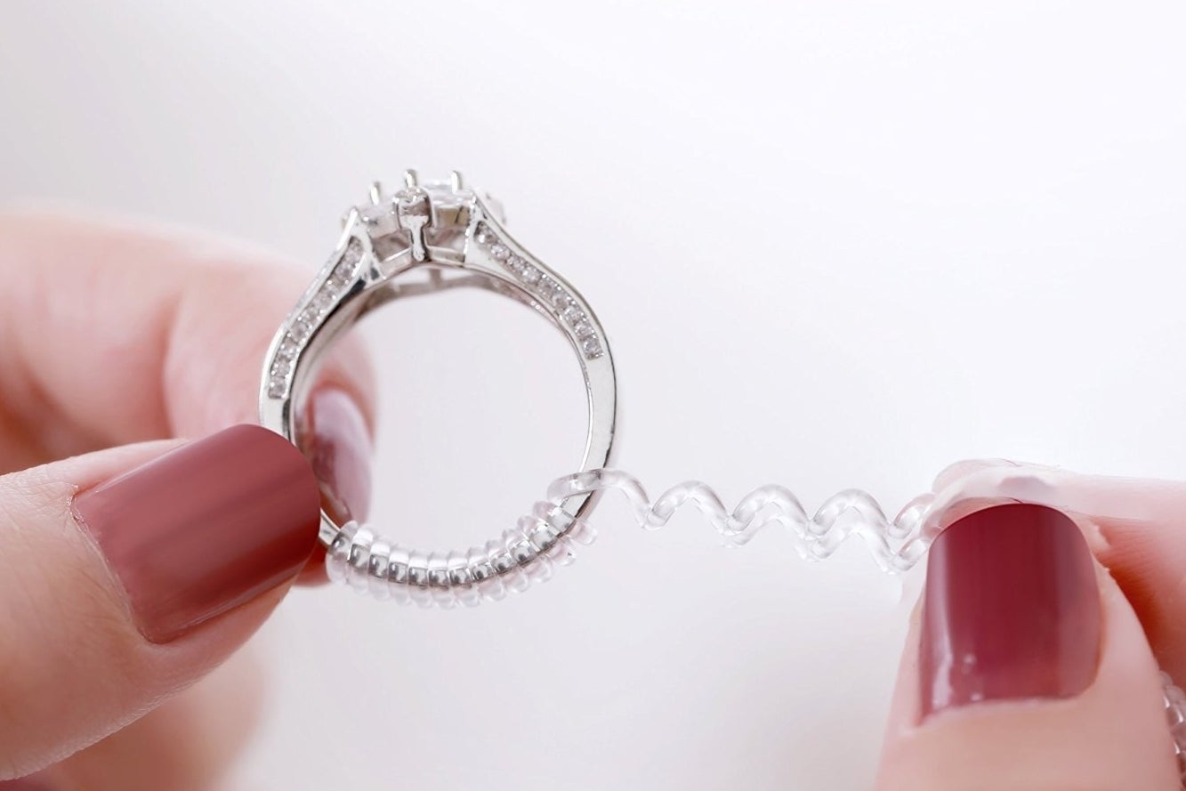 Hands winding the spiral onto an engagement-like ring