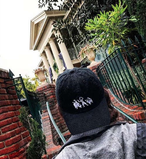 black baseball cap with the ghosts from haunted mansion embroidered on it 