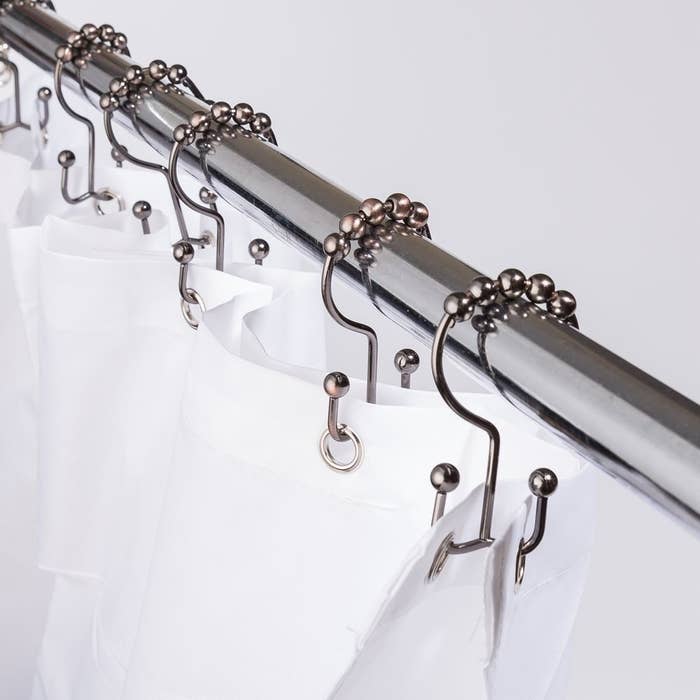 the double shower hooks holding up a curtain and a liner 