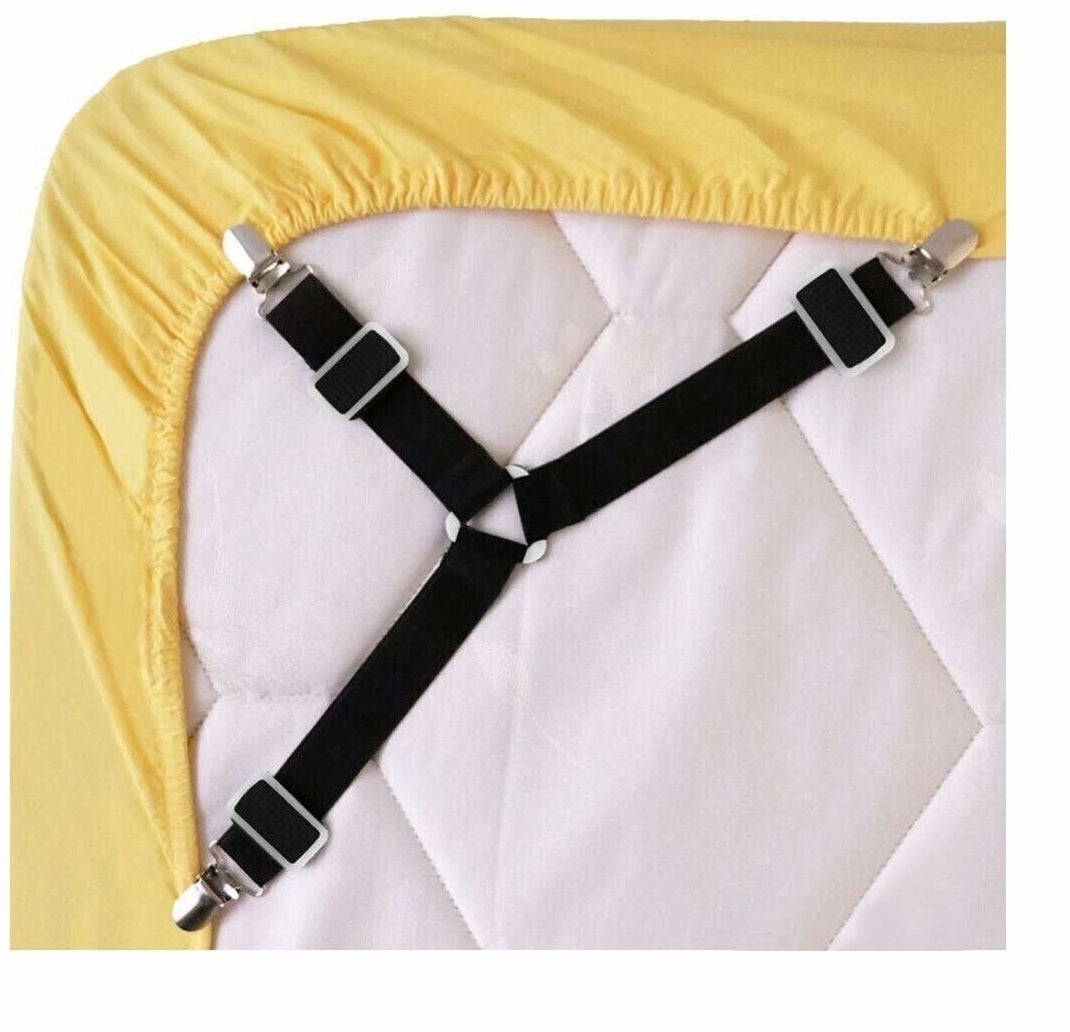 three connected straps with clips holding a fitted sheet taught on the underside of a mattress