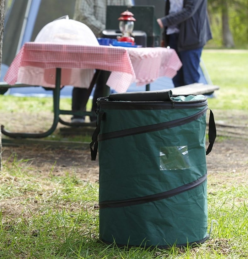 The green fabric bag, with a zippered top and black spirals where the wires hold it upright