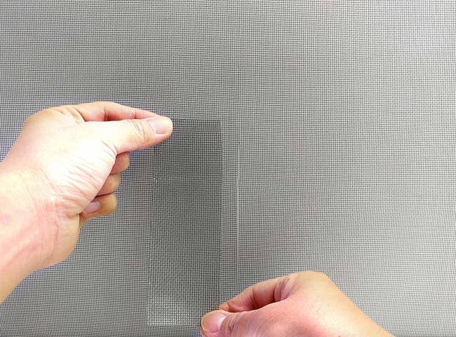 hands placing the screen tape on a screen 