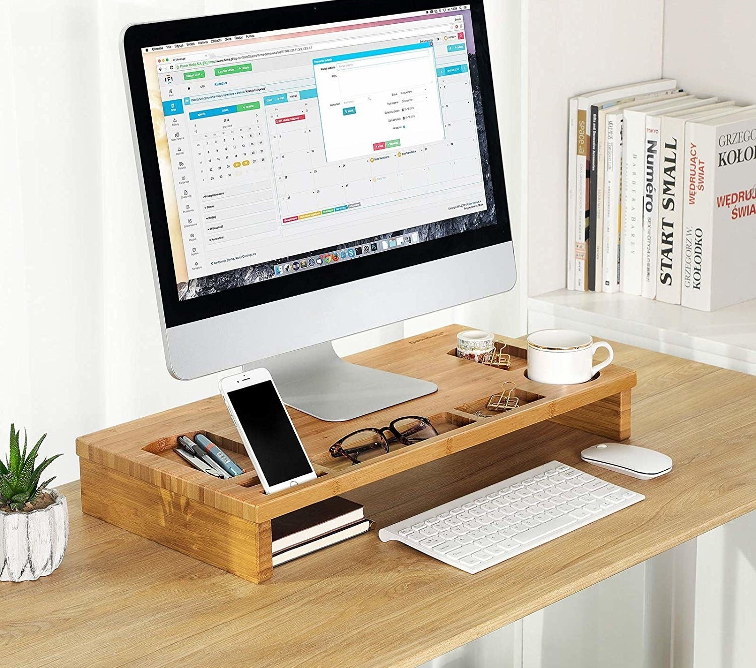 the stand rise with two storage drawers propping up a desktop and an iphone