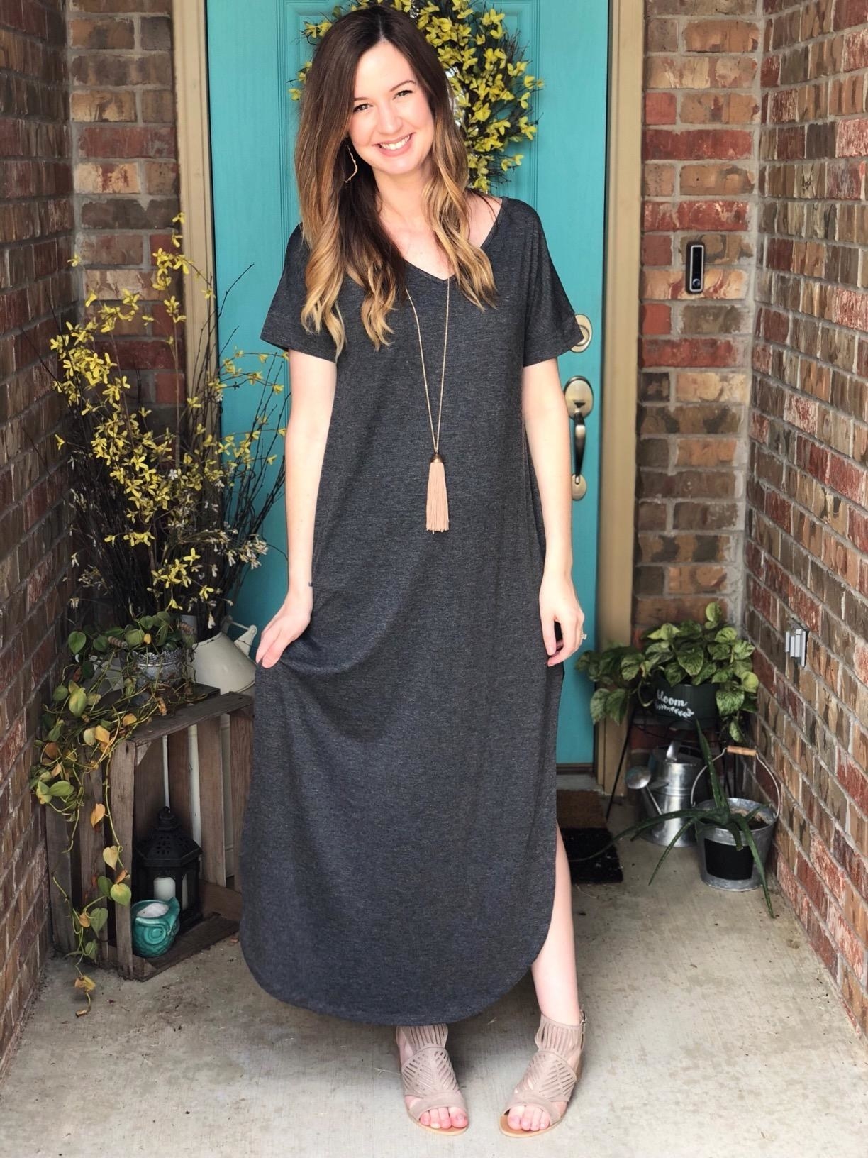 reviewer in gray short-sleeve maxi dress with side slits and a curved hem