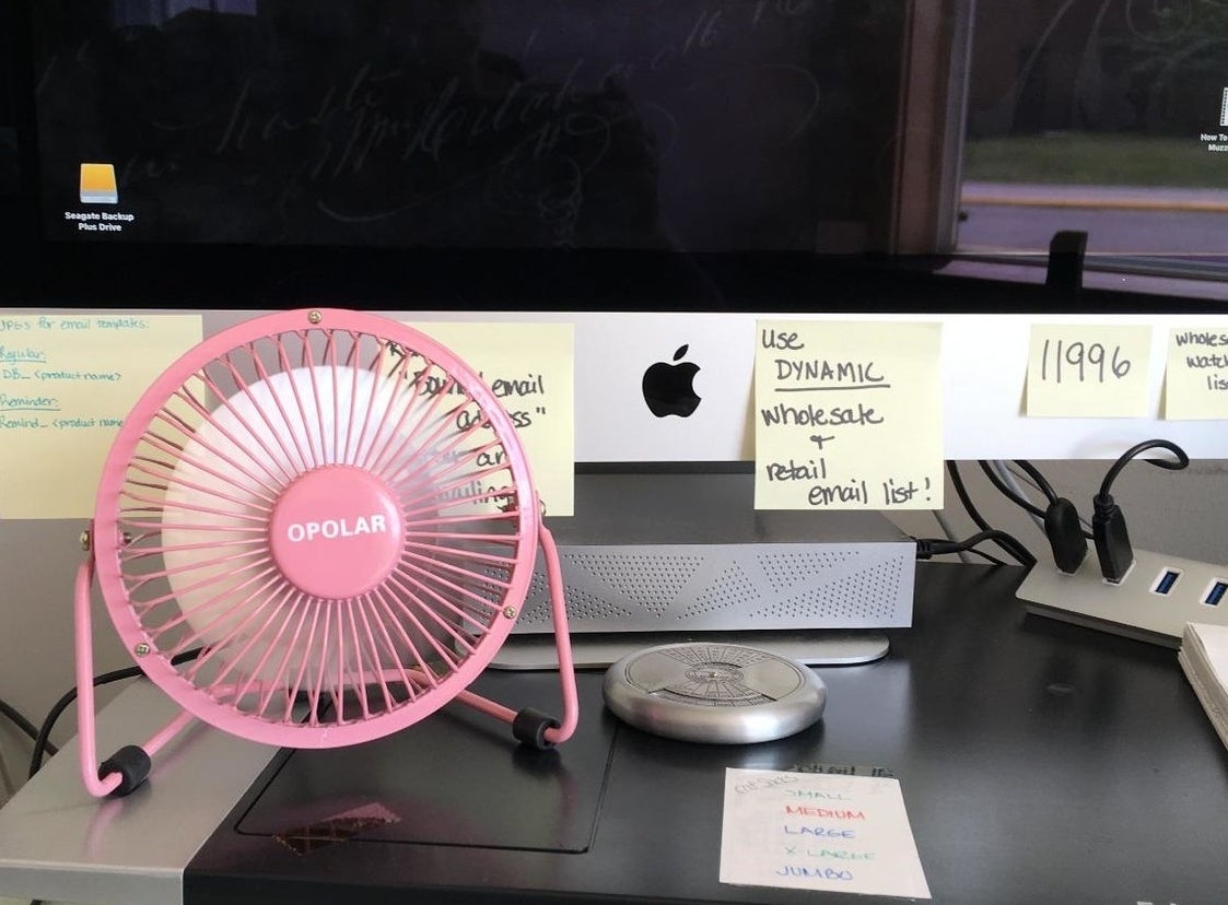 the pink desk fan on a desk in front of an apple monitor