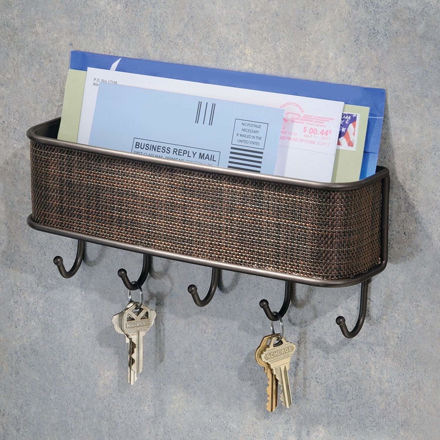 It has a basket for mail to sit in on top; the front is covered with a brown basketweave pattern; and there are five small hooks for keys at the bottom