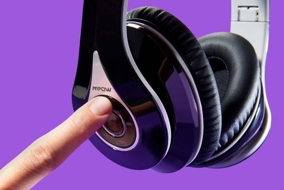 Closeup of the headphones with a finger pressing the conveniently located buttons