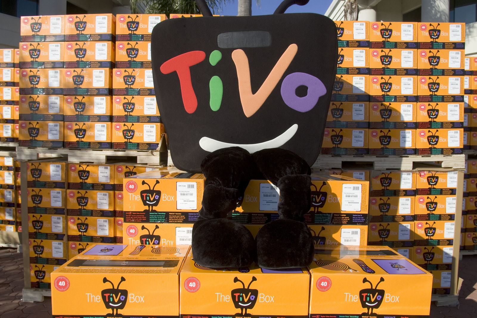 The TiVo mascot sitting on a bunch of orange boxes.  