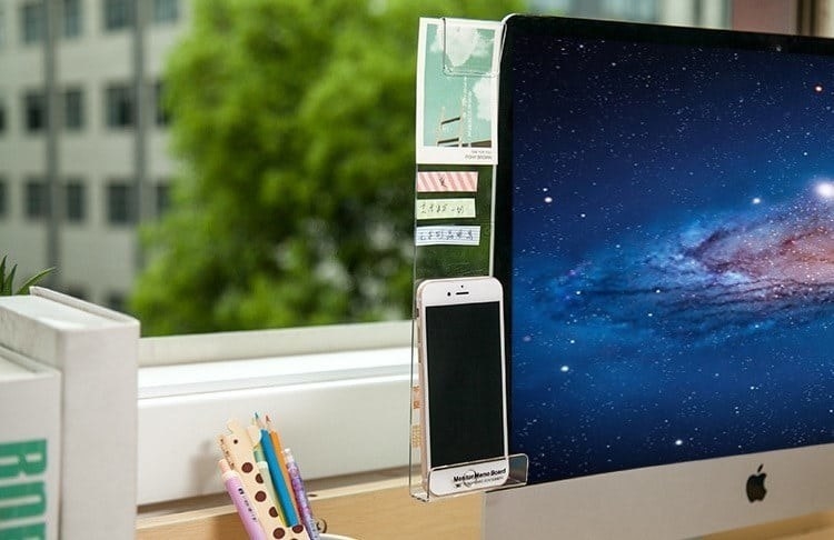 acrylic board attached to a computer screen with a phone on it