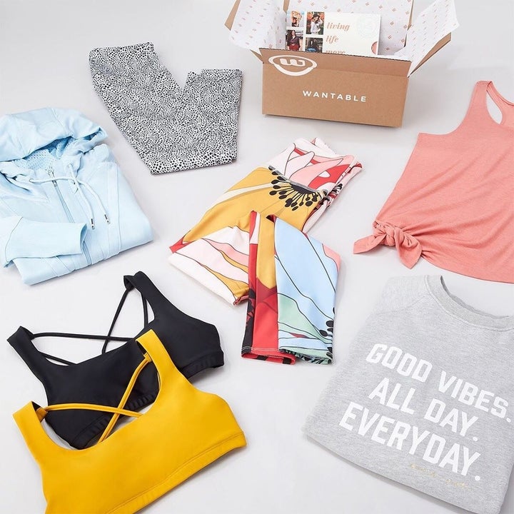 wantable fitness box surrounded by 2 sports bras, 2 leggings, a tank, a hoodie, and a sweatshirt