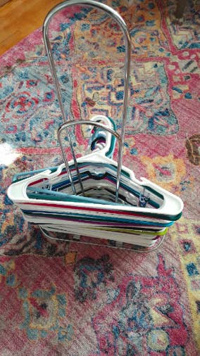 a reviewer photo of the silver stacker with the hangers neatly piled on it 
