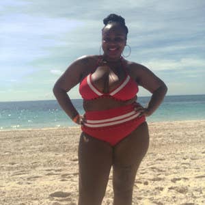 A customer review photo of them in the swimsuit in red on a beach