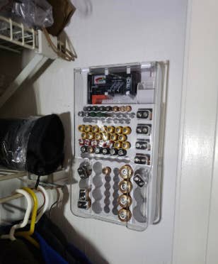 a reviewer photo of the battery organizer mounted on the garage wall