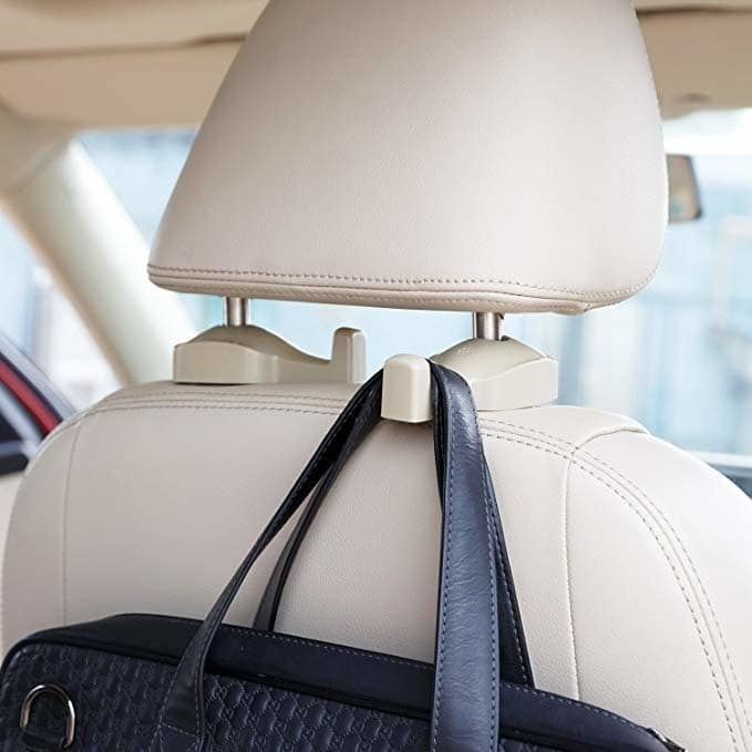 A purse hanging on the clip that&#x27;s attached to the headrest