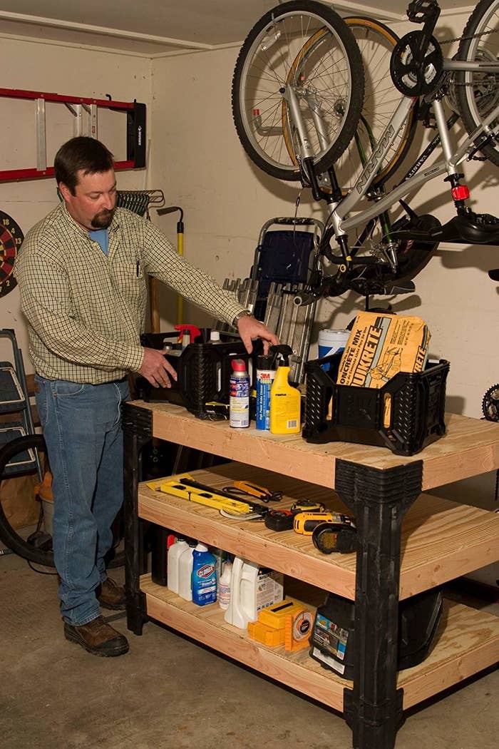 a model organizing his tools on the three tiers of the wooden workbench