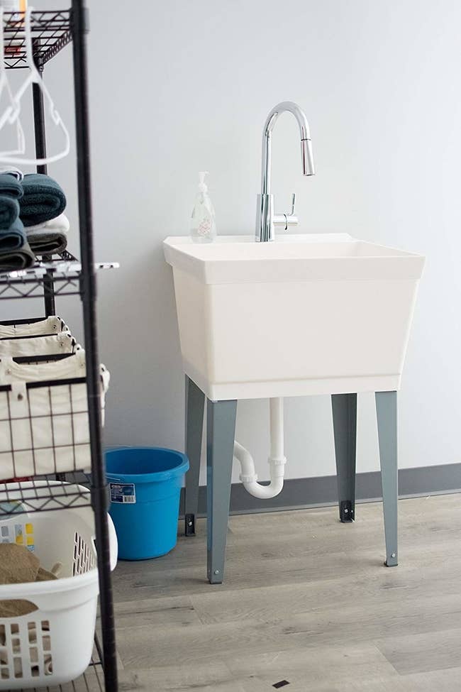 a white slop sink with silver legs