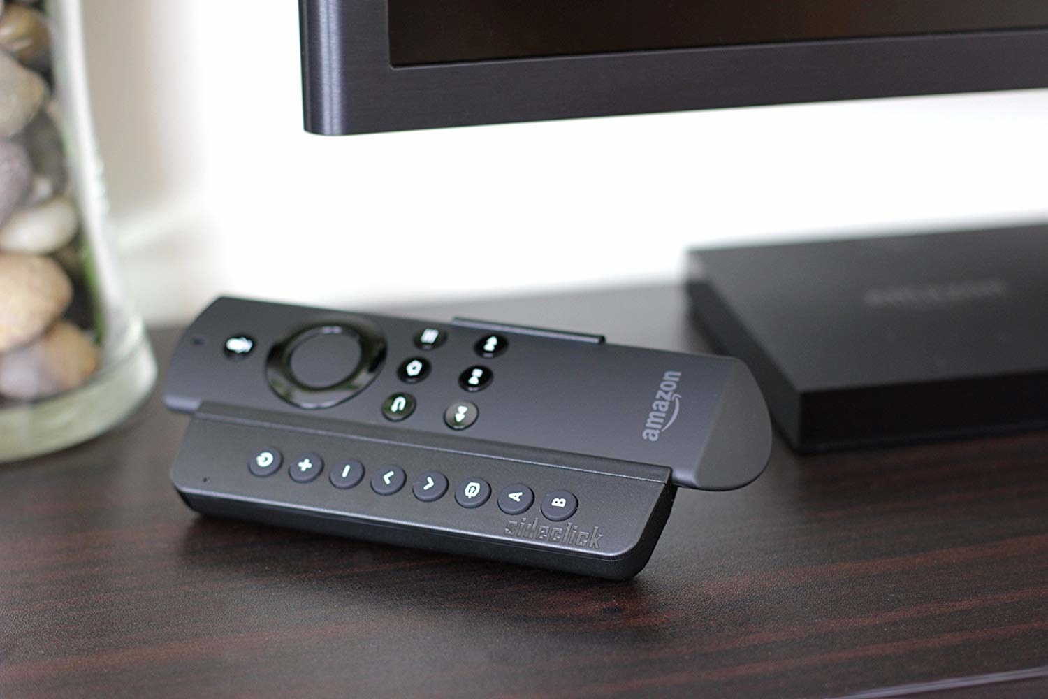 the amazon firestick remote sitting inside of the attachment which is kind of like a case with buttons