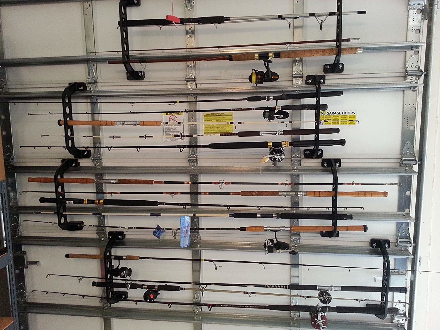 a bunch of fishing rods neatly organized against a garage wall