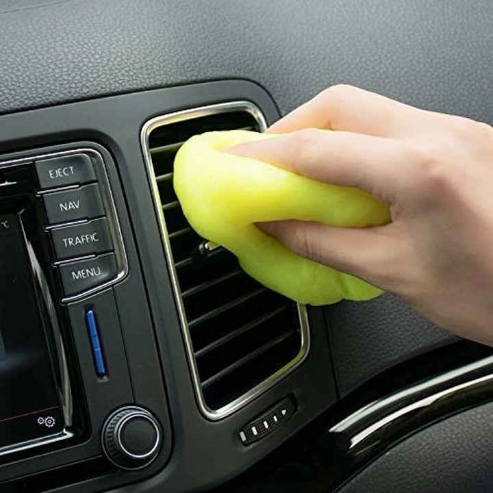 model uses yellow glob to clean car vent