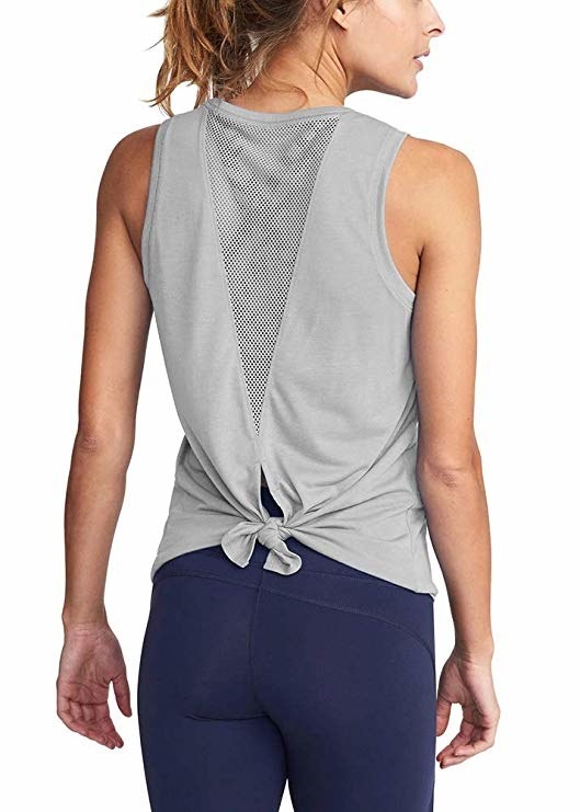 a model showing the back of the gray tank top with a mesh cutout in the center