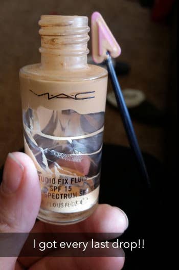 A reviewer photo showing a MAC foundation bottle with the foundation scooped out of the edges with the beauty spatula with a caption 