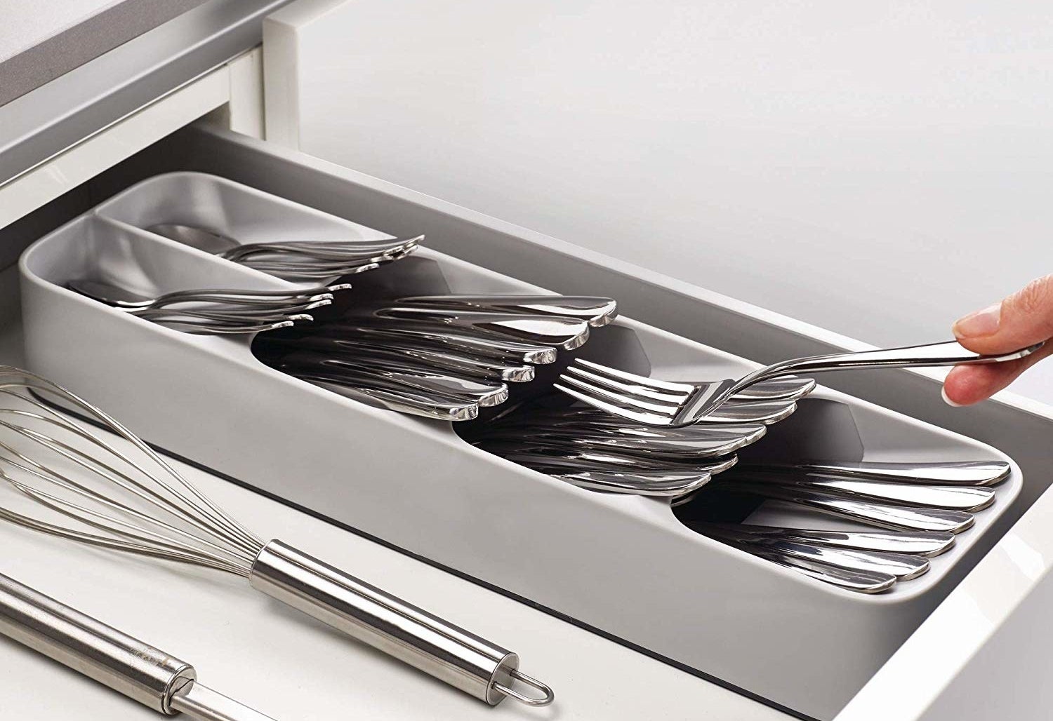 person putting a fork into the cutlery organizer