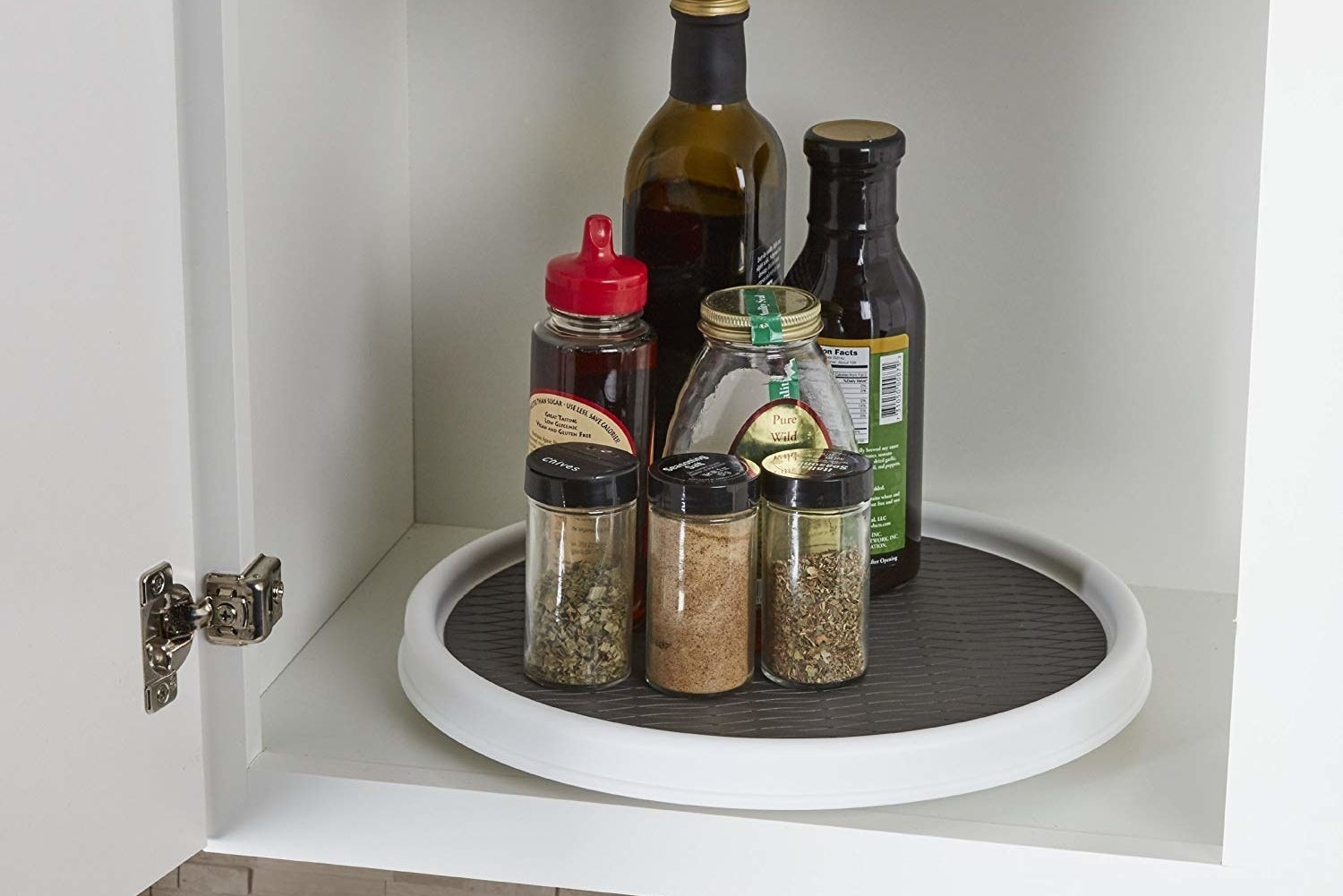 the lazy susan in cabinet with spices and condiments on it