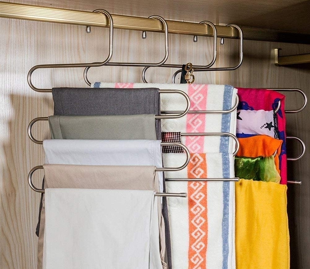 various s-shaped hangers holding multiple clothing items on them