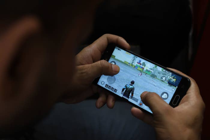 A young boy plays PUBG on his mobile phone at a restaurant in New Delhi on May 3.