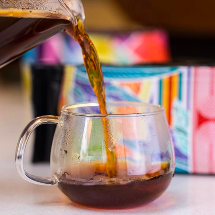 An action shot of coffee being poured into a glass cup