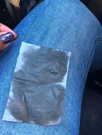 a reviewer showing the oil that came off with the product soaked into the tissue