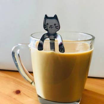 Cat-shaped stirring spoon propped against a cup of coffee