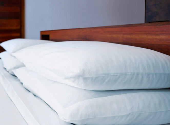 A lifestyle shot of four low-loft pillows, two on each side of the bed 