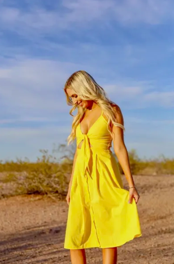 A different reviewer wearing the dress in bright yellow.