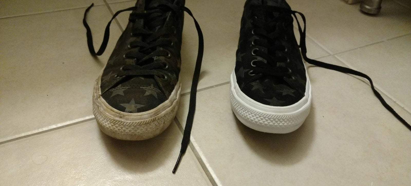 A reviewer&#x27;s pair of sneakers: one with very dirty soles and sides and the other looking basically brand new white
