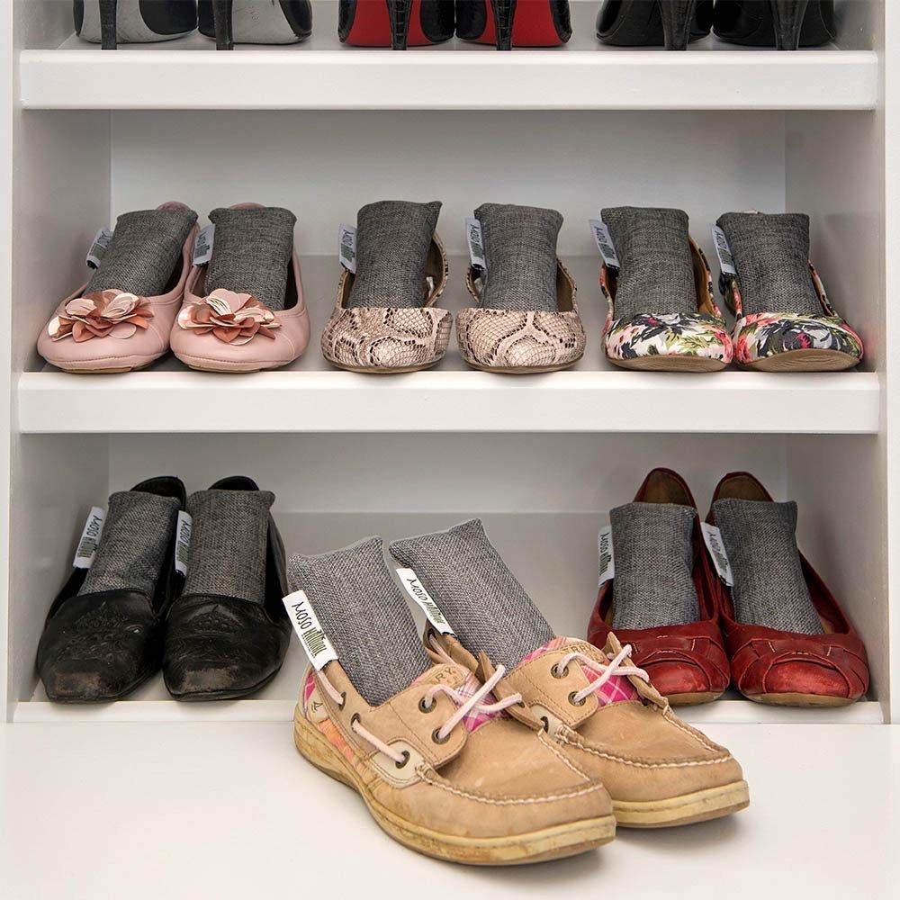 Three shelves of shoes, with each shoe having the rectangular grey fabric pouch inside