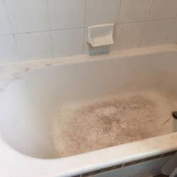 A stained and dirty reviewer bath tub