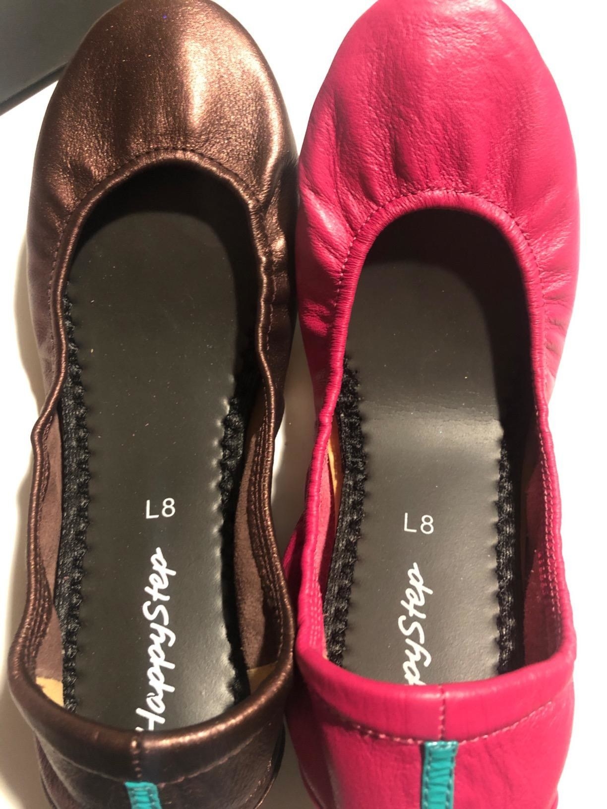 reviewer shows two flats with black cushy soles inside 