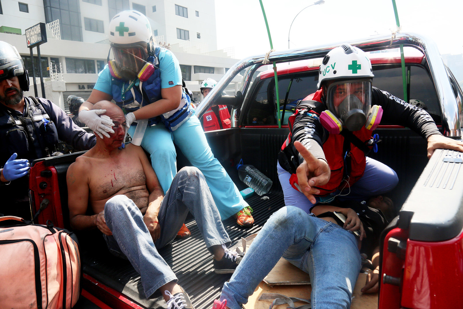 Paramedics tend to two pro-Guaidó demonstrators who were wounded in a clash with police forces, April 30, in Caracas, Venezuela.