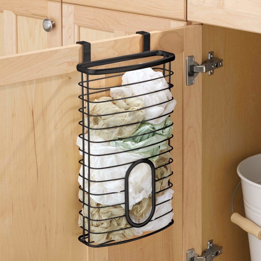 The black metal organizer with an oval-shaped opening in the middle so you can grab a bag